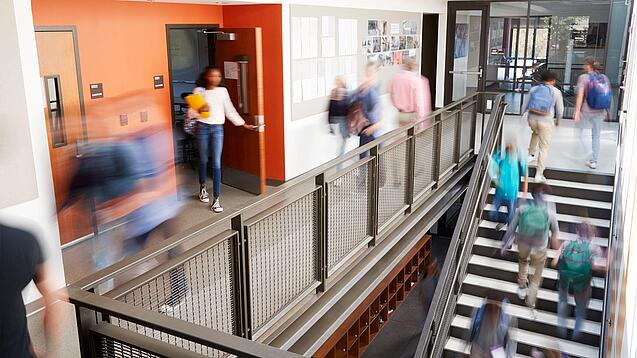 Schülerinnen und Schüler sind unterwegs in einem Schulgebäude.