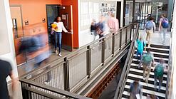 Schülerinnen und Schüler sind unterwegs in einem Schulgebäude.