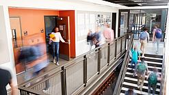 Schülerinnen und Schüler sind unterwegs in einem Schulgebäude.