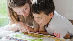 Zwei Kinder lesen in einem Buch.