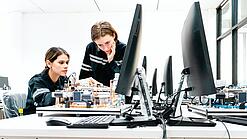 Zwei Junge Frauen vor einem Computer an einem technischen Projekt