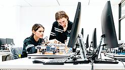 Zwei Junge Frauen vor einem Computer an einem technischen Projekt