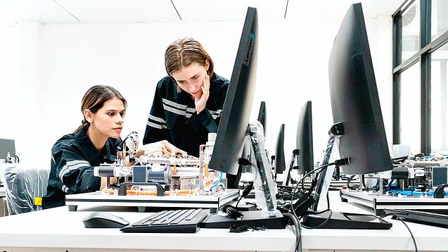 Zwei Junge Frauen vor einem Computer an einem technischen Projekt