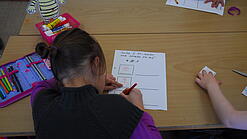 Kinder schreiben Texte in einem Klassenzimmer.