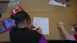 Kinder schreiben Texte in einem Klassenzimmer.