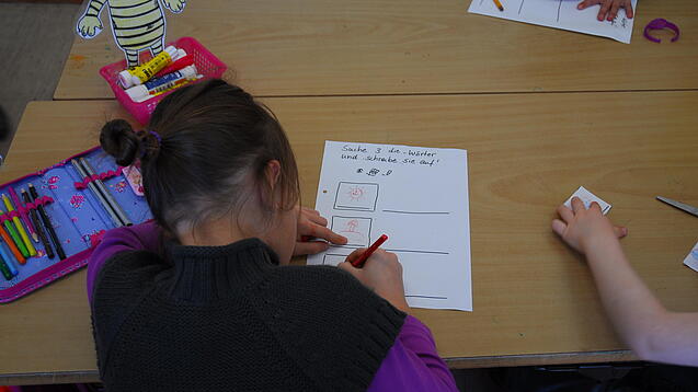 Kinder schreiben Texte in einem Klassenzimmer.