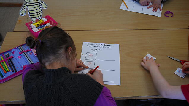 Kinder schreiben Texte in einem Klassenzimmer.