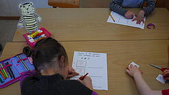 Kinder schreiben Texte in einem Klassenzimmer.