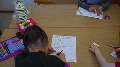 Kinder schreiben Texte in einem Klassenzimmer.