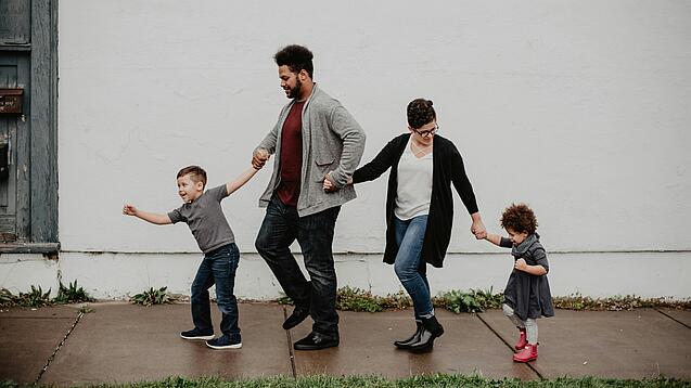 Zwei Erwachsene und zwei Kinder halten sich an den Händen.