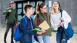 Gruppe von Jugendlichen vor einem Schulgebäude.