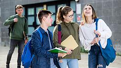 Gruppe von Jugendlichen vor einem Schulgebäude.