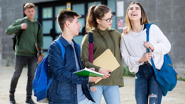 Gruppe von Jugendlichen vor einem Schulgebäude.