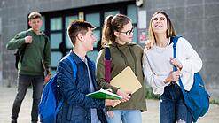 Gruppe von Jugendlichen vor einem Schulgebäude.