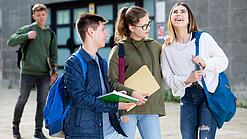 Gruppe von Jugendlichen vor einem Schulgebäude.