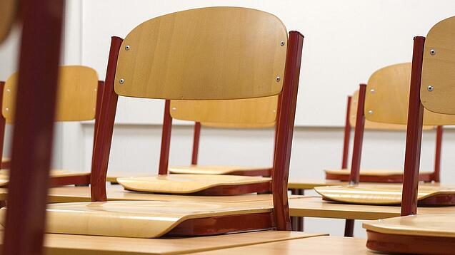 Ein Klassenzimmer, in dem die Stühle auf die Tische hochgestellt sind.