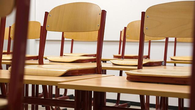Ein Klassenzimmer, in dem die Stühle auf die Tische hochgestellt sind.