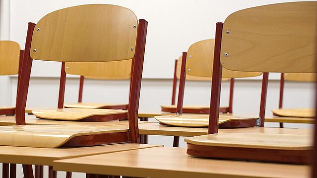 Ein Klassenzimmer, in dem die Stühle auf die Tische hochgestellt sind.