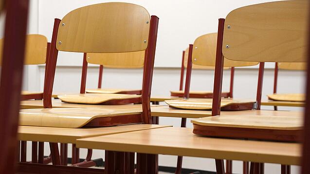 Ein Klassenzimmer, in dem die Stühle auf die Tische hochgestellt sind.
