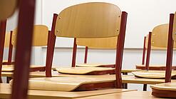 Ein Klassenzimmer, in dem die Stühle auf die Tische hochgestellt sind.