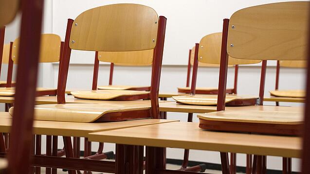 Ein Klassenzimmer, in dem die Stühle auf die Tische hochgestellt sind.