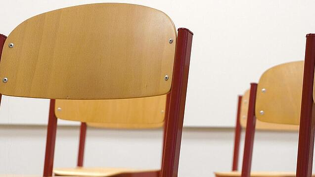 Ein Klassenzimmer, in dem die Stühle auf die Tische hochgestellt sind.