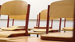 Ein Klassenzimmer, in dem die Stühle auf die Tische hochgestellt sind.