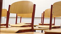 Ein Klassenzimmer, in dem die Stühle auf die Tische hochgestellt sind.