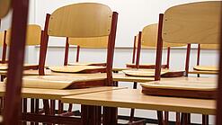 Ein Klassenzimmer, in dem die Stühle auf die Tische hochgestellt sind.