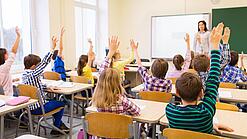 Eine Lehrerin steht vor einer Schulklasse. 