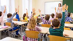 Eine Lehrerin steht vor einer Schulklasse. 