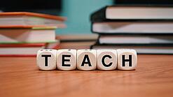 Buchstabenbauklötze bilden das Wort "Teach".