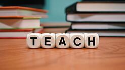 Buchstabenbauklötze bilden das Wort "Teach".