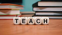 Buchstabenbauklötze bilden das Wort "Teach".