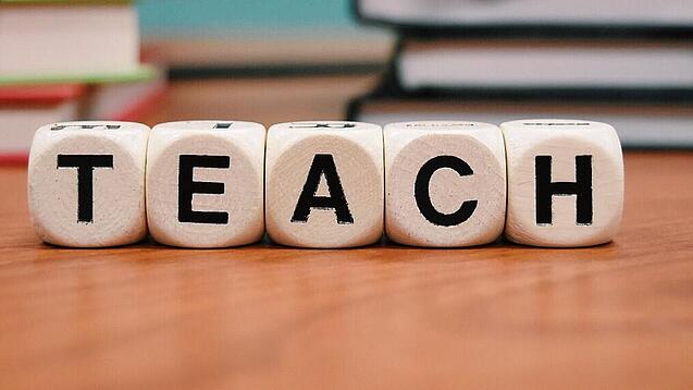Buchstabenbauklötze bilden das Wort "Teach".