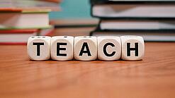 Buchstabenbauklötze bilden das Wort "Teach".