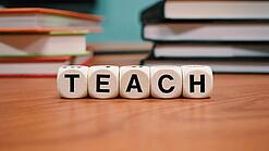 Buchstabenbauklötze bilden das Wort "Teach".