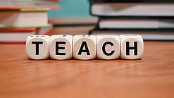 Buchstabenbauklötze bilden das Wort "Teach".