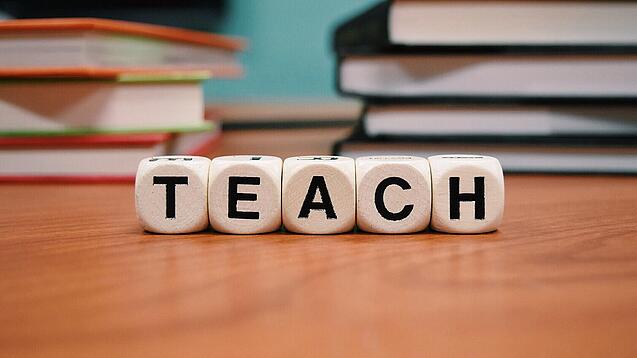 Buchstabenbauklötze bilden das Wort "Teach".