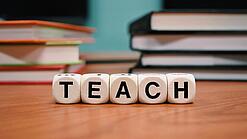 Buchstabenbauklötze bilden das Wort "Teach".