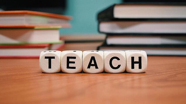 Buchstabenbauklötze bilden das Wort "Teach".