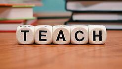 Buchstabenbauklötze bilden das Wort "Teach".