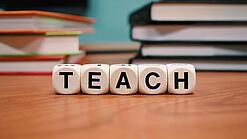Buchstabenbauklötze bilden das Wort "Teach".