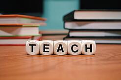 Buchstabenbauklötze bilden das Wort "Teach".