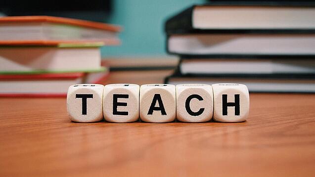 Buchstabenbauklötze bilden das Wort "Teach".