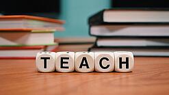 Buchstabenbauklötze bilden das Wort "Teach".