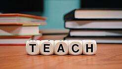 Buchstabenbauklötze bilden das Wort "Teach".