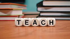 Buchstabenbauklötze bilden das Wort "Teach".