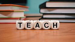 Buchstabenbauklötze bilden das Wort "Teach".