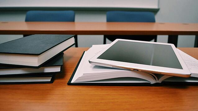 Tablet und Bücher auf einem Pult.